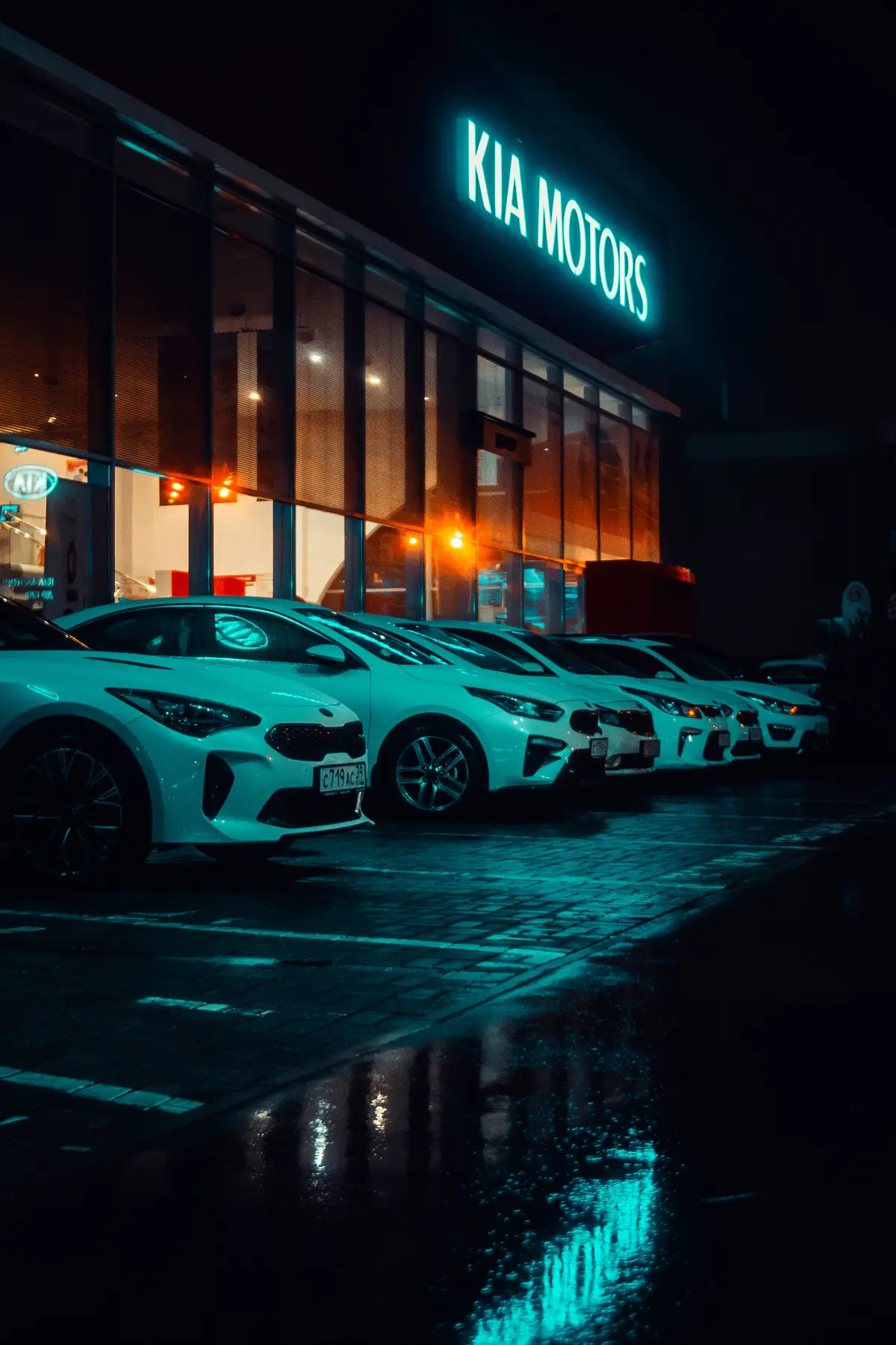 Vehicle inventory outside an illuminated car dealership